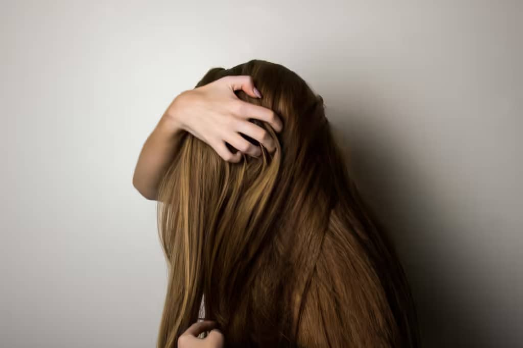 pexels-photo-1159334-1159334 An artistic close-up of a woman's long brunette hair held gently by her hand, emphasizing texture and color.